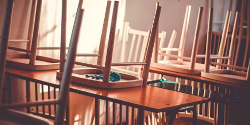 photo of an empty classroom with chairs on the tables